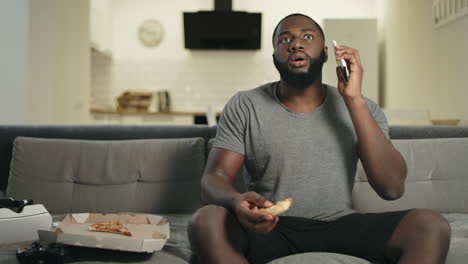 Surprised-guy-watching-tv-in-open-kitchen.-Shocked-man-stopping-with-surprise