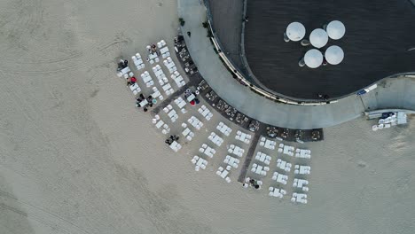 Toma-Aérea-Estática-De-Arriba-Hacia-Abajo-De-Mesas-Vacías-De-Restaurante-De-Playa-En-La-Arena