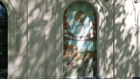 a picture in the window of the facade of an old castle in zywiec - sundial