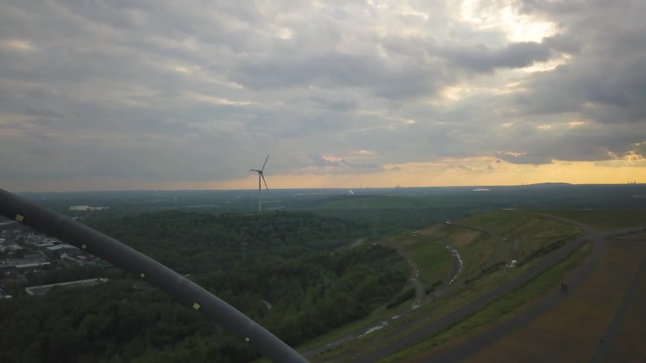 아름다운 일몰과 함께 멀리서 회전하는 풍력 터빈 블레이드의 공중 전망