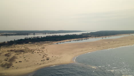 Aerial-trucking-shot-along-sandy-shore-of-Baltic-Sea-and-Natural-Reserve-Area-in-background