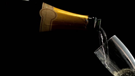 champagne pouring into a glass on a dark background