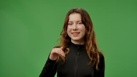 young woman posing in front of green screen