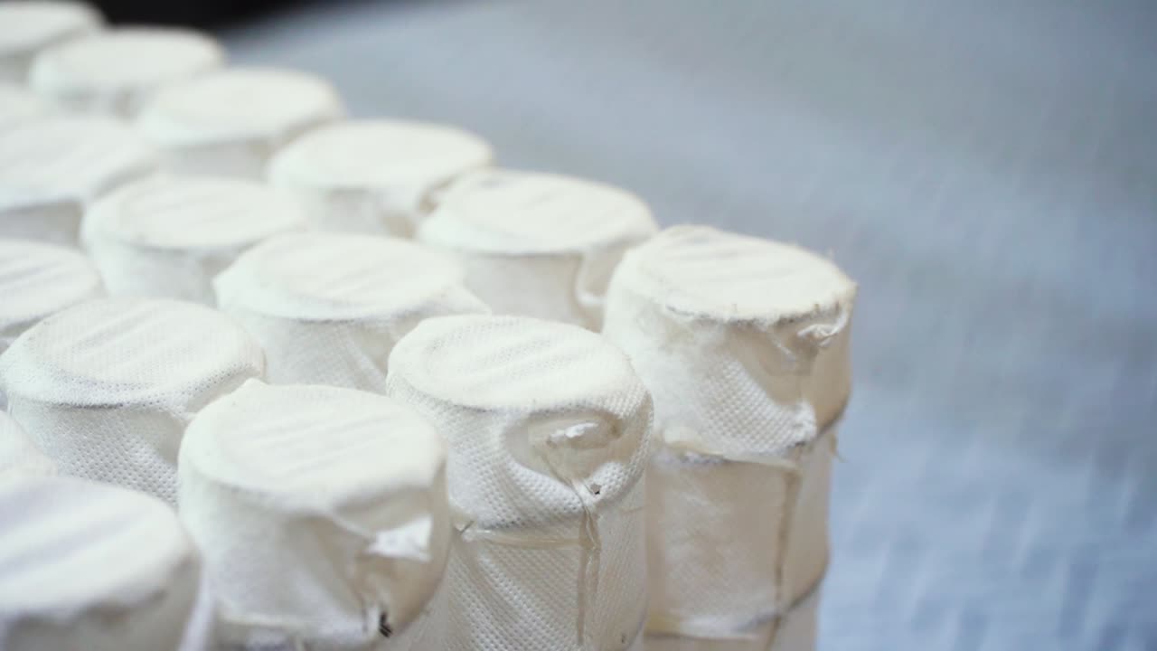 varias filas de colchones de cama sellados industriales, resortes de descanso de comodidad interior, bobinas de bolsillo en la refrigeración, tela de sueño de muebles de algodón