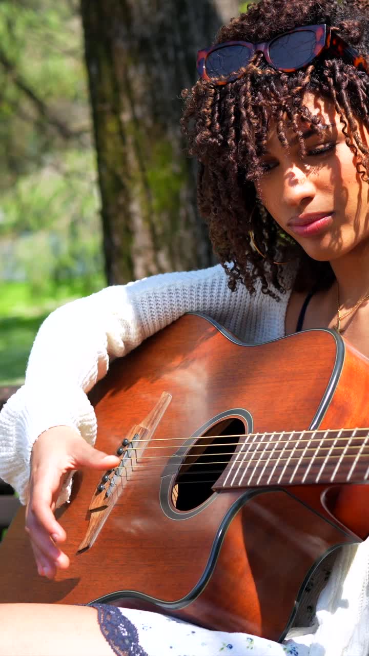 mujer tocando la guitarra al aire libre