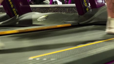 a powerful women doing a workout in a gym on a treadmill , close up shot