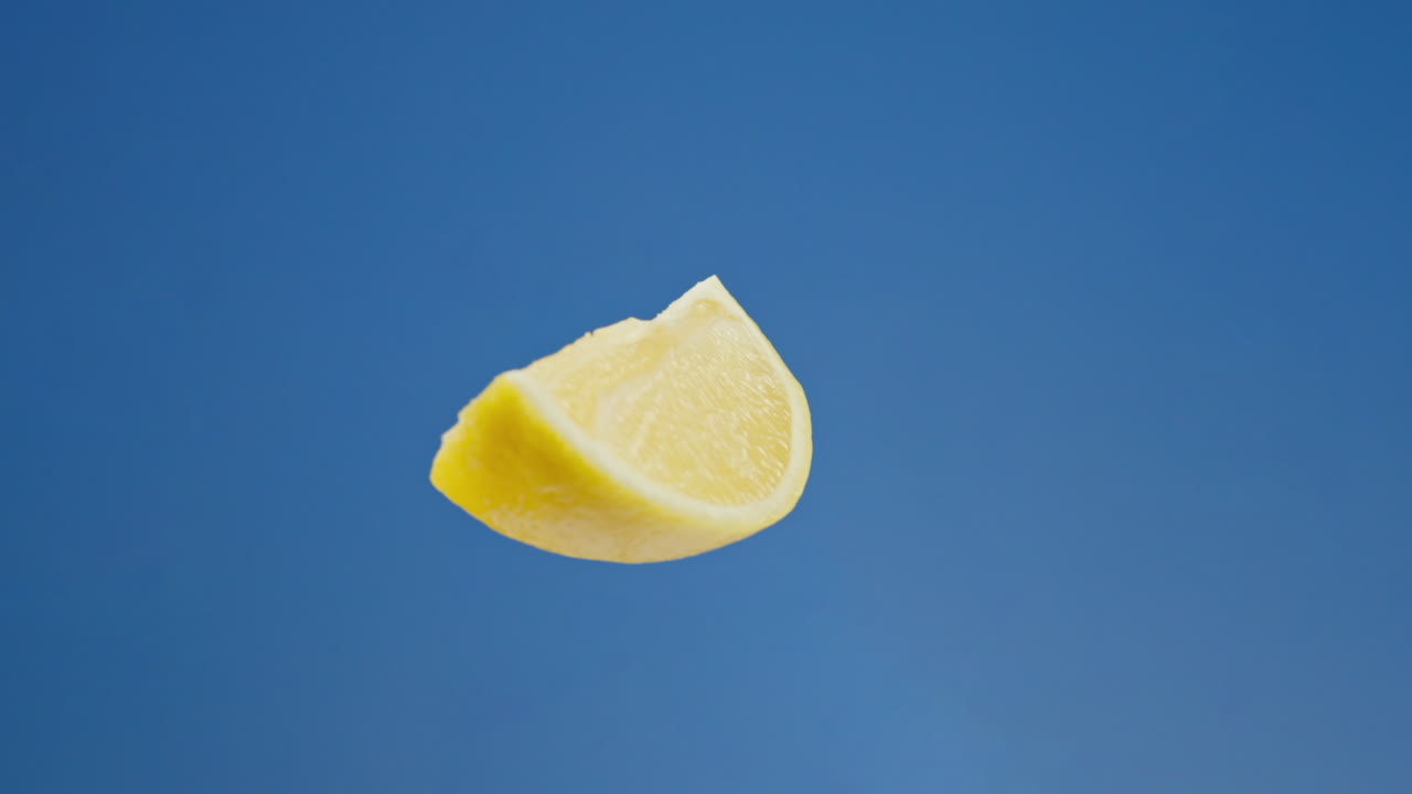 Lemon slice spinning on blue background