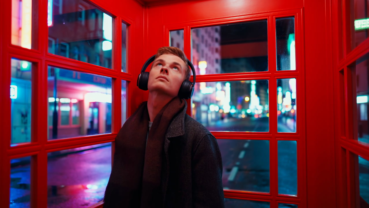 Young White Man In Red Booth Listening To Music On Headphones Amid Neonlit City Night, Contemplative Traveler
