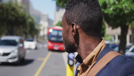 hombre de negocios afroamericano mirando a su alrededor en una concurrida calle de la ciudad