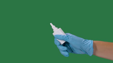 manos masculinas con guantes de protección presionan una botella de medicamento nasal con spray desinfectante. protección contra el coronavirus. prevención de una pandemia de covid 2019. pantalla verde, llave de croma. cámara lenta. primer plano