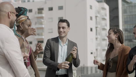 hombre feliz bailando y abriendo una botella de champán en una fiesta de negocios