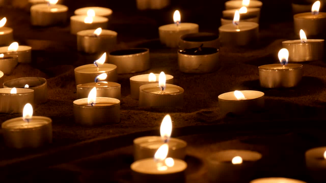 Candele che bruciano nella sabbia