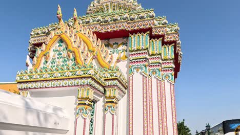 colorful temple architecture with passing tourists and bus