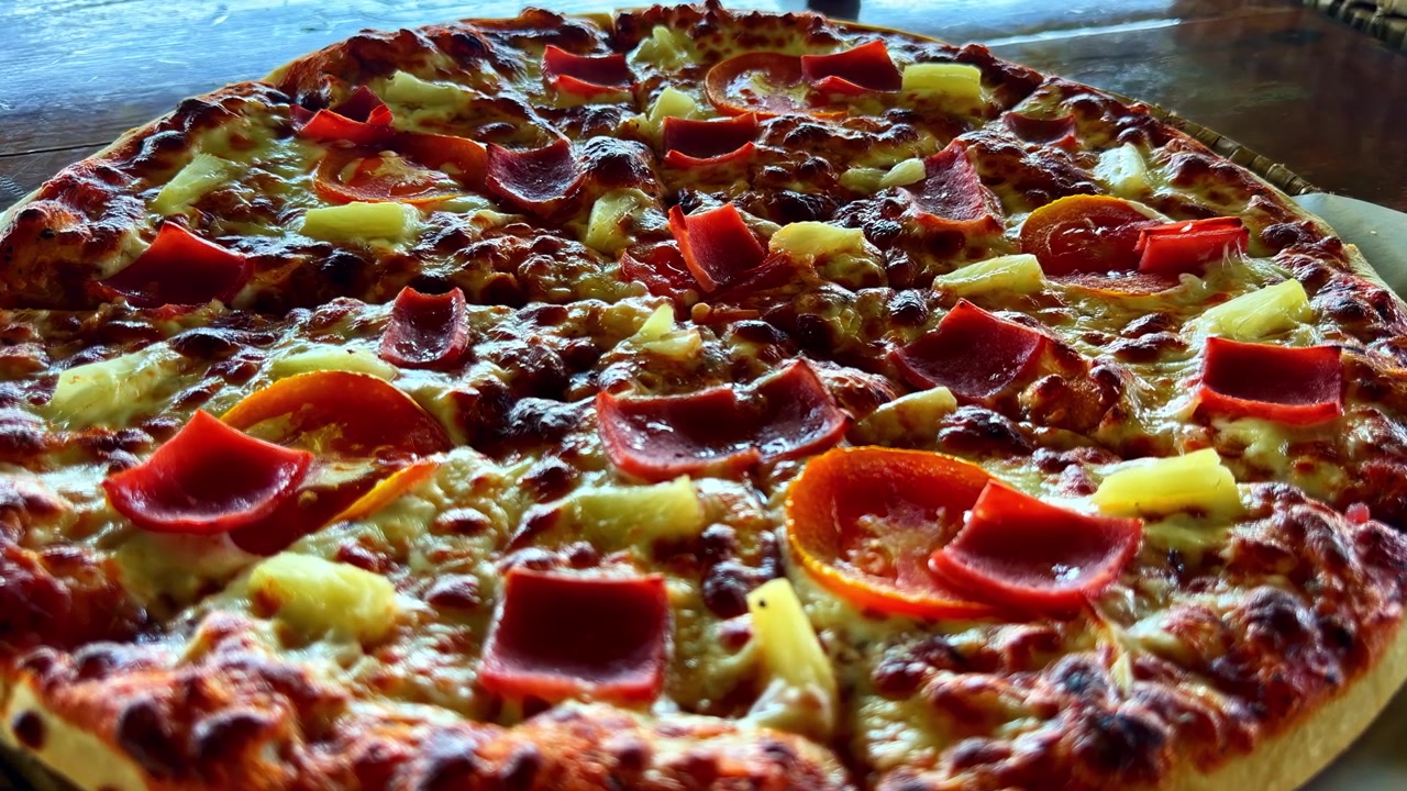 Pizza hawaiana appena sfornata con prosciutto e formaggio
