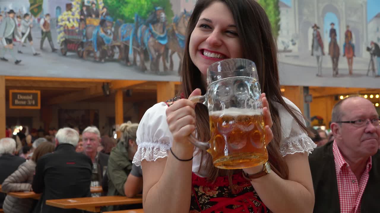Uma garota bonita bebe uma caneca grande de cerveja na Oktoberfest, Alemanha.