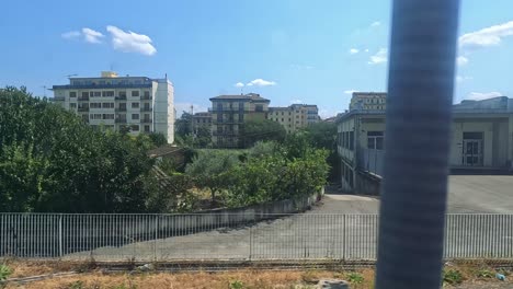 train passing industrial and urban landscapes in naples