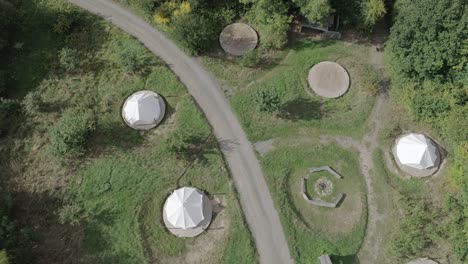 aerial top down shot tracking forward over a group of tents or often referred to as yurts or roundhouses