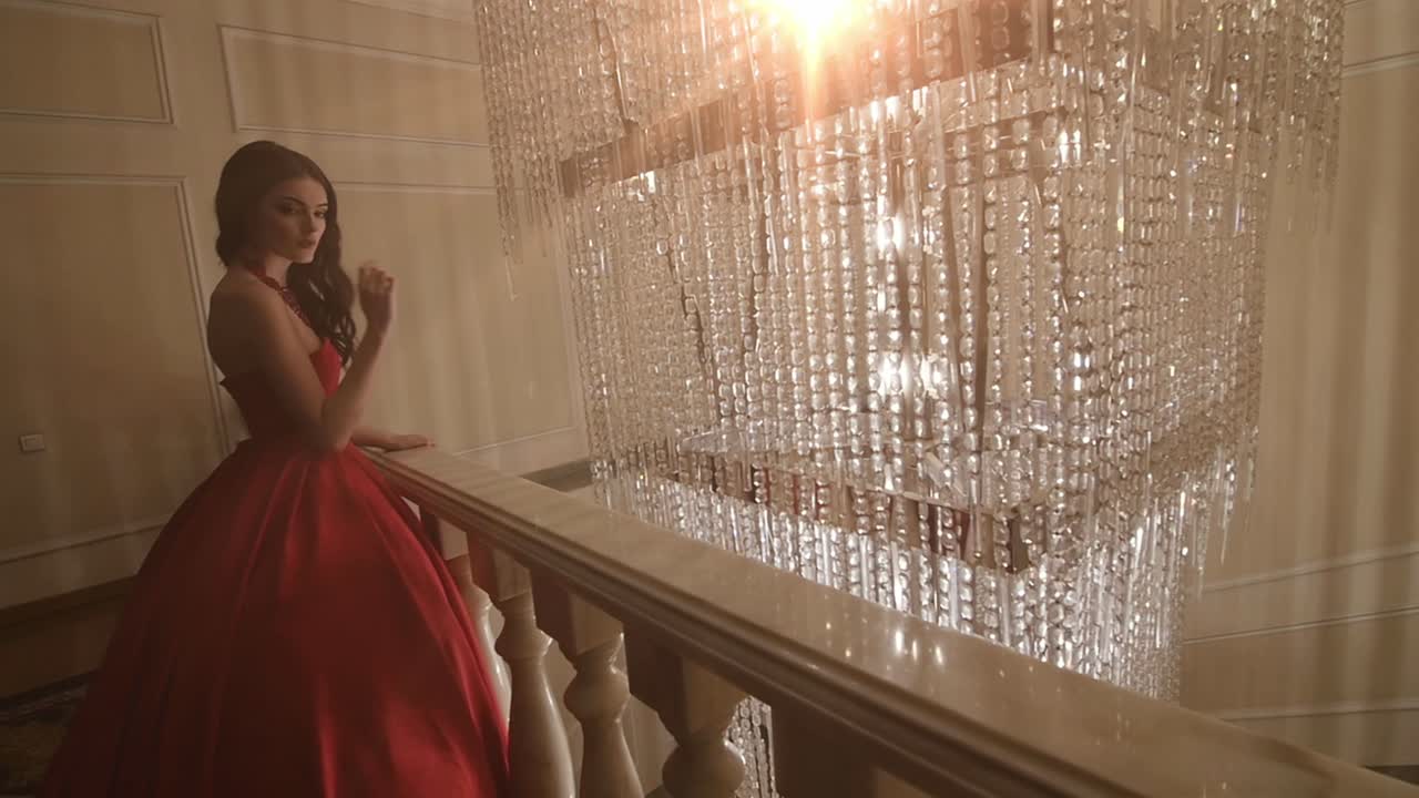 Elegant Woman in Red Gown on Grand Staircase