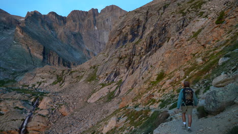 Cinematic-first-light-hiker-walking-to-climb-Longs-Peak-14er-sunrise-Rocky-Mountain-National-Park-above-treeline-Colorado-Denver-Boulder-Estes-Park-summer-green-dramatic-landscape-pan-slowly-left