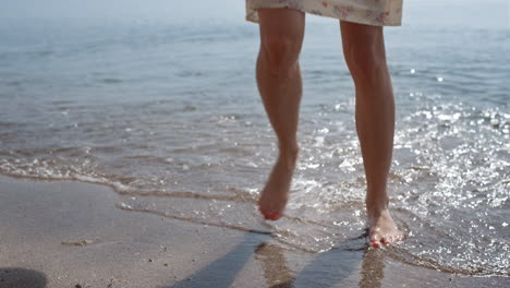 mujer despreocupada desconocida corriendo sobre las olas del mar en cámara lenta. piernas delgadas mujer