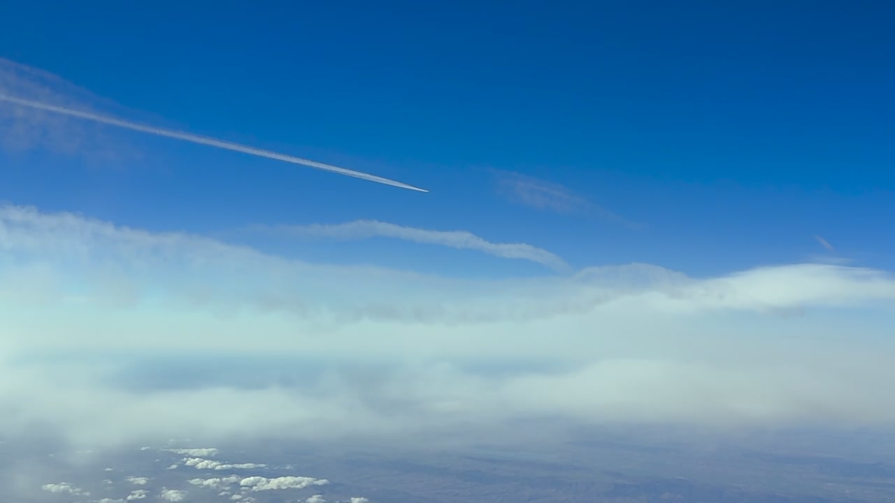 Aerial view taken from a jet airplane cockpit flying in the upper atmosphere at 120000m high in a blue sky.