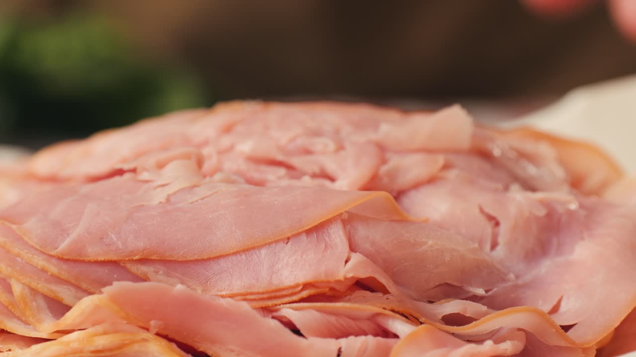 Mortadella ham sandwich, Traditional italian focaccia filled with thin pesto slices of mortadella, served by chef man in cafe restaurant. Macro of traditional italian spanish tapas antipasti.