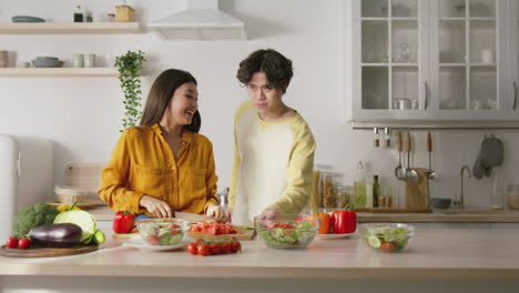 family preparing a salad together in the kitchen