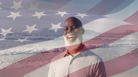 animación de la bandera de los estados unidos de américa sobre un hombre afroamericano mayor feliz en la playa