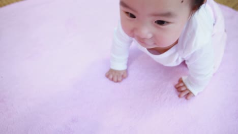 asian baby crawling on blanket