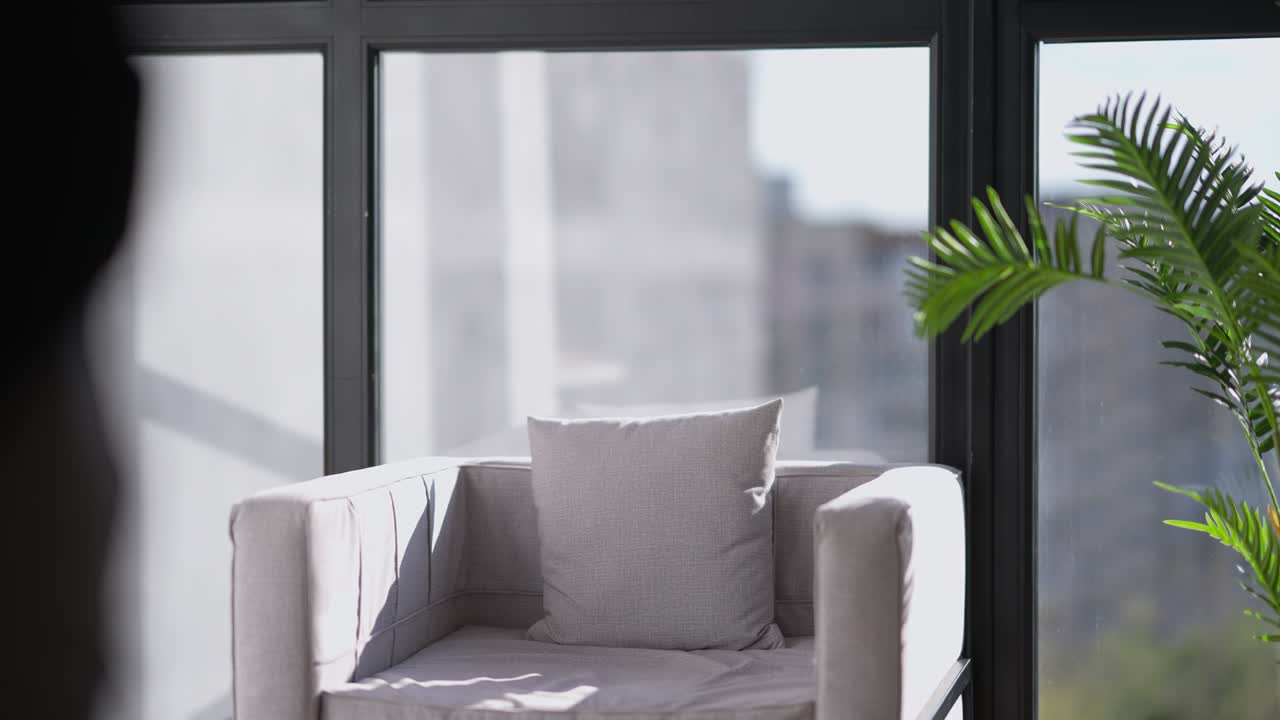 창문 에 있는 편안한 의자에서 일어서서 서류와 함께 걸어가는 잘생긴 자신감 넘치는 남자, 중동 사업가의 초상화.