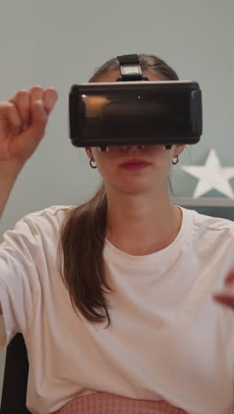 woman with spinal cord injury sits in wheelchair moving hands. young person with disability in vr goggles enjoys modern technology at home closeup