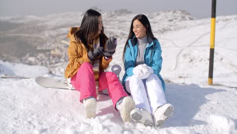 Zwei-Junge-Snowboarderinnen-Unterhalten-Sich