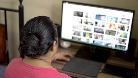 mujer caucásica asiática india que trabaja en una computadora de escritorio en casa
