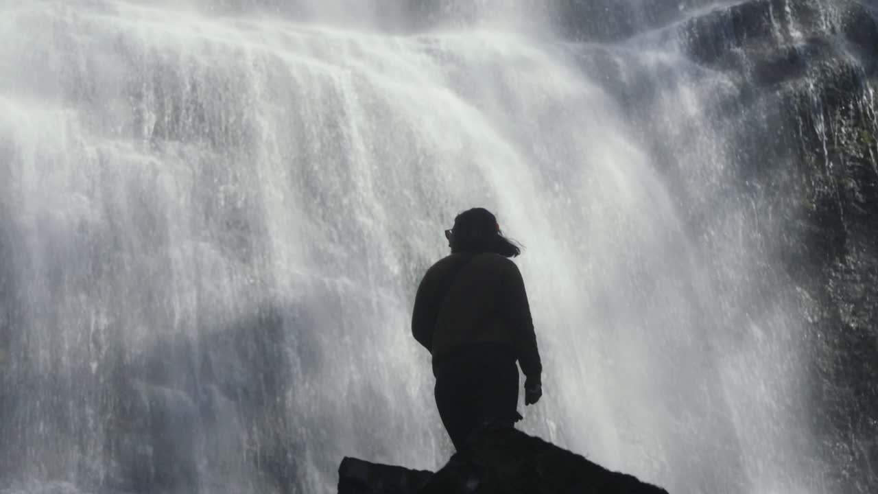 Silueta de mujer de pie frente a las Cataratas Bridal Veil en Columbia Británica, Canadá.