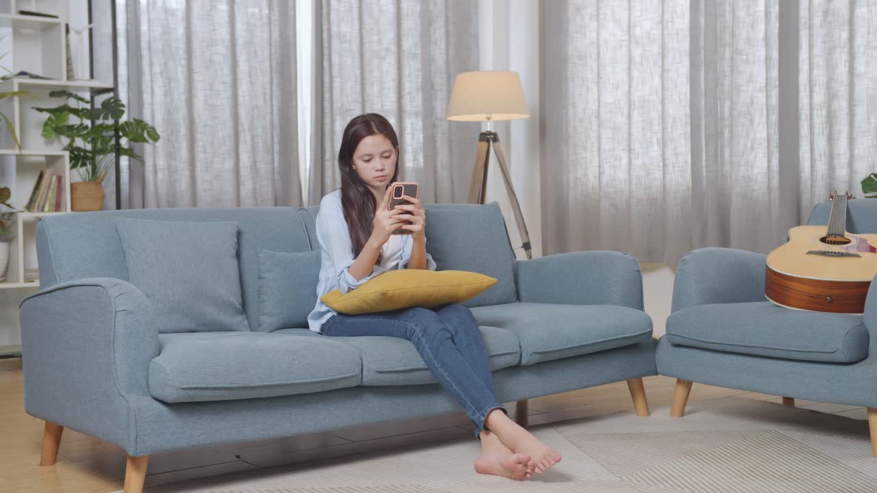 거실 의 소파 에 스마트폰 을 사용하는 여자