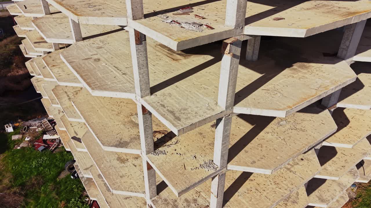 Construction site aerial view shows unfinished building with rusted beams