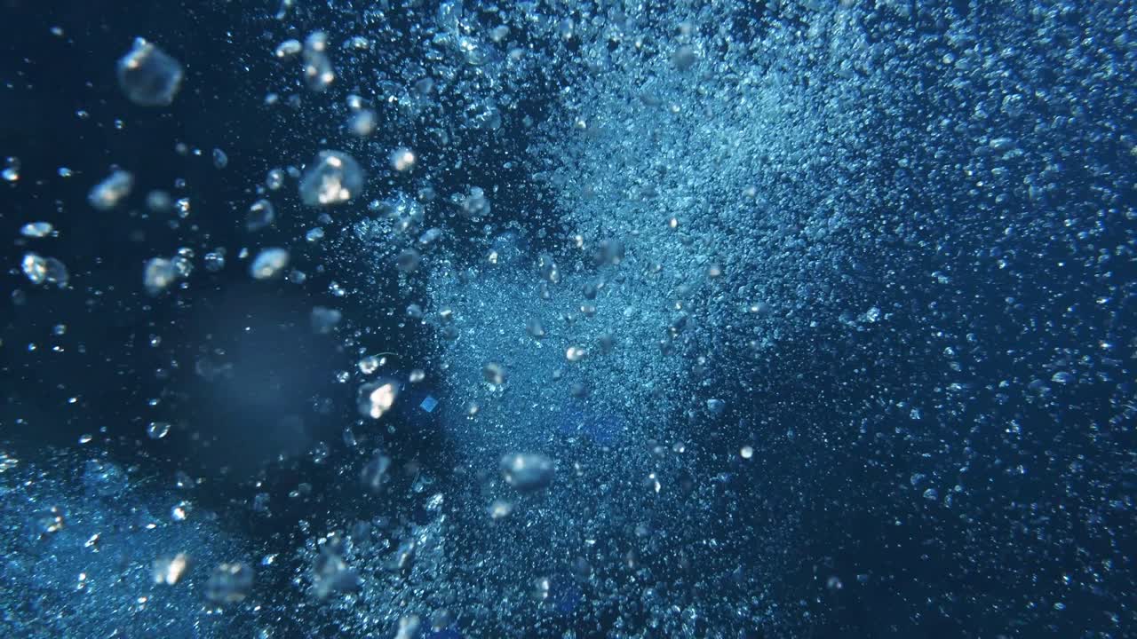 Vertical shot of air bubbles floating to the surface with bokeh effect