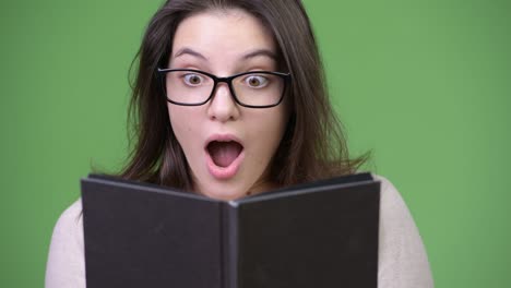 young beautiful woman looking shocked while studying