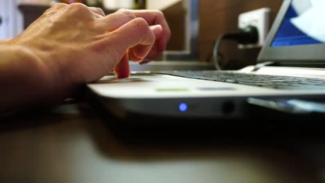 womens hands typing and using laptop keyboard as camera slowly moves away from hands