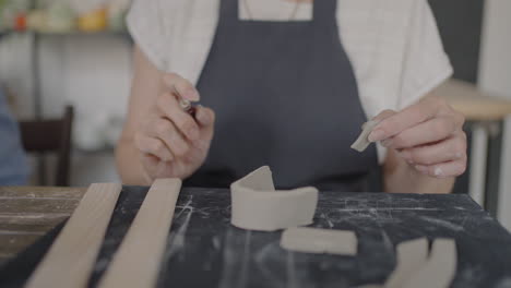 three elderly people work on a potter's wheel in slow motion