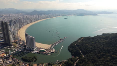 a sweeping drone view highlights balneario camboriu's expansive coastline, marina tedesco, ilha das cabras, and iconic skyline including yachthouse towers, one tower, and infinity coast tower