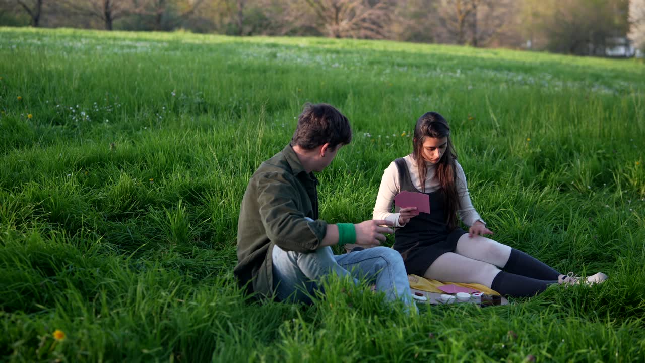 Couple Playing Cards in a Park
