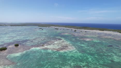 Aerial-drone-view-over-Los-Roques-archipelago-with-vivid-turquoise-waters-and-protected-wetlands,-bright-day