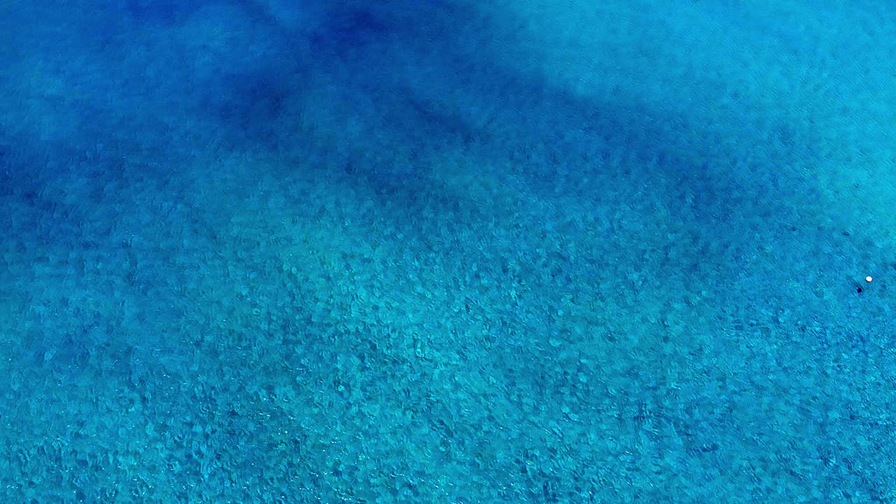 Beautiful tones of a blue and clear ocean shot from above