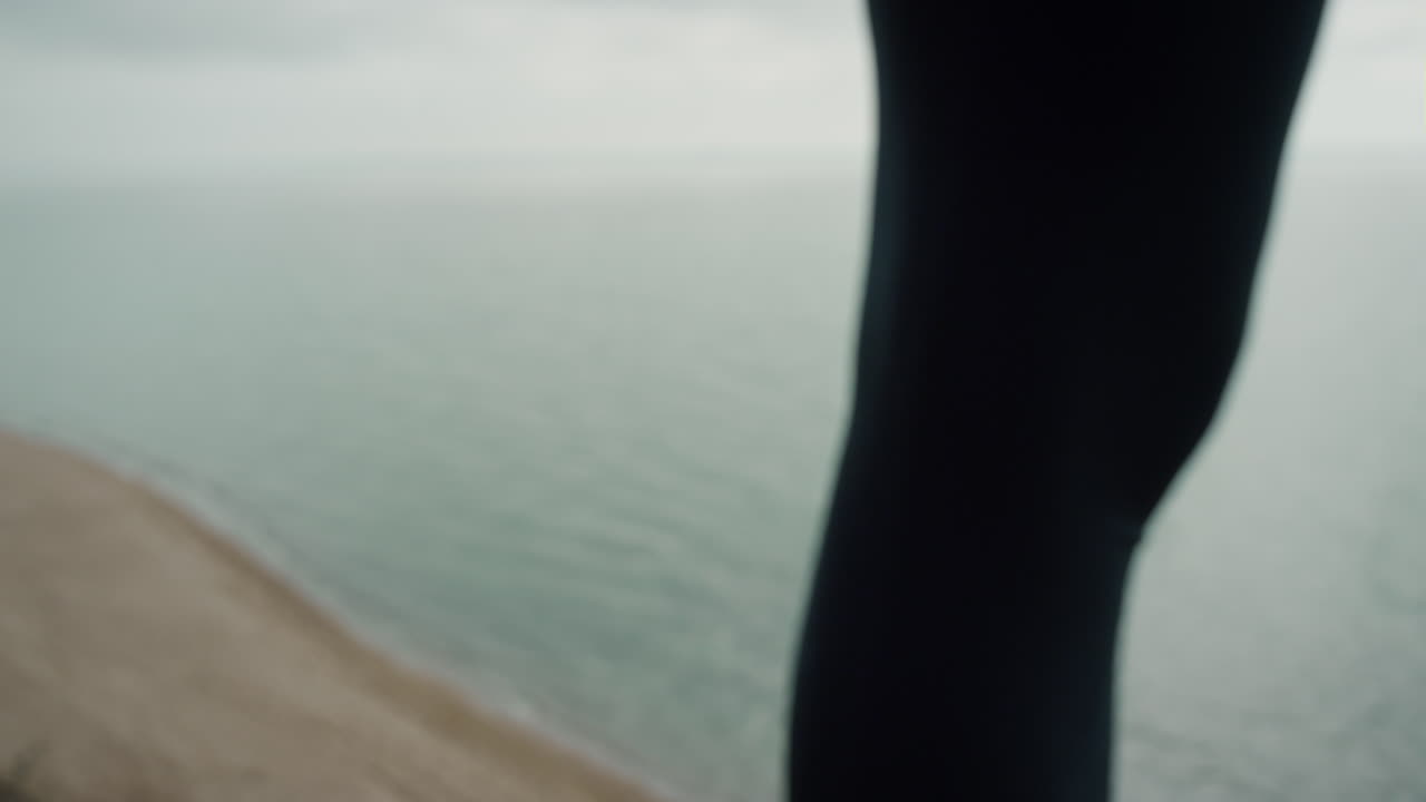 Nahaufnahme einer Athletin, die am Strand steht. Perfekte körperliche Verfassung einer Sportlerin.