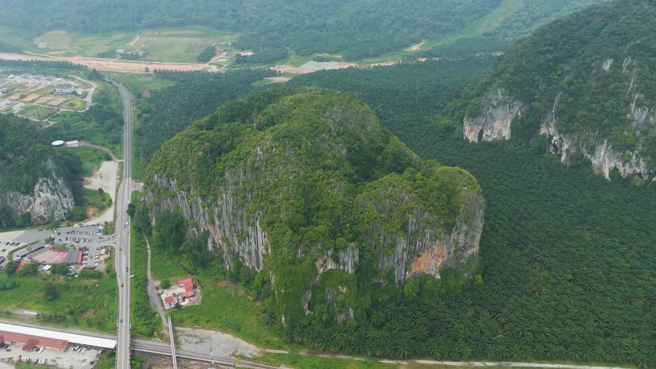 Toàn cảnh Kelantan, Malaysia, với những ngọn đồi đá vôi hùng vĩ được bao quanh bởi các đồn điền dầu cọ rộng lớn, hòa quyện giữa các khối đá tự nhiên và cảnh quan canh tác