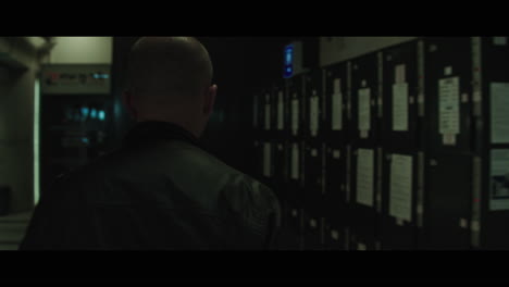 a bald dangerous looking man opens train station locker