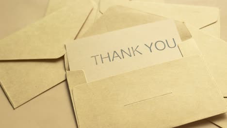 thank you message and envelope on wooden table