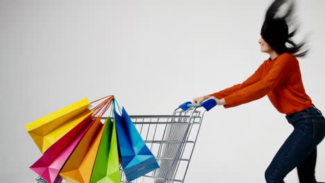 woman pushing shopping cart with colorful bags