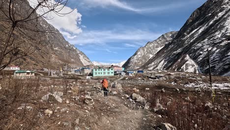 Hiker-in-red-jacket-taking-a-photo-on-arrival-in-Langtang-village